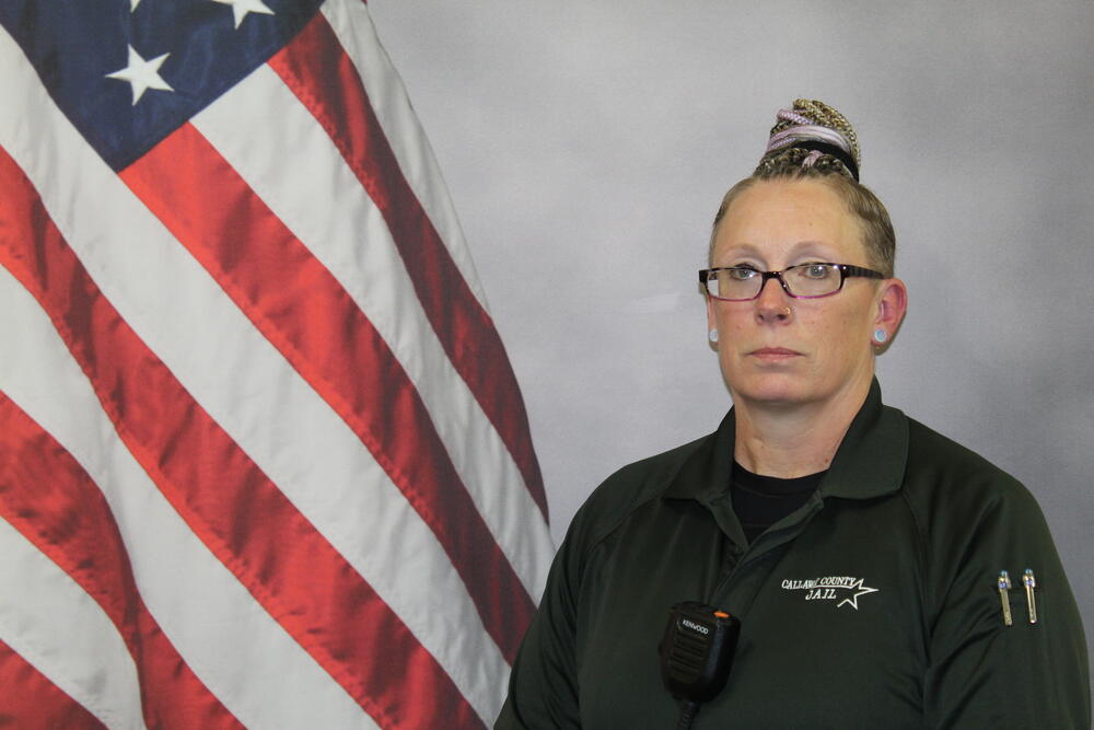 Lt Stacie Vandeusen pictured in uniform in front of an American Flag.